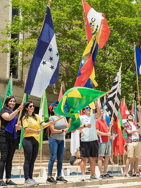 在2022全球街区派对上，学生们挥舞着来自不同国家的国旗
